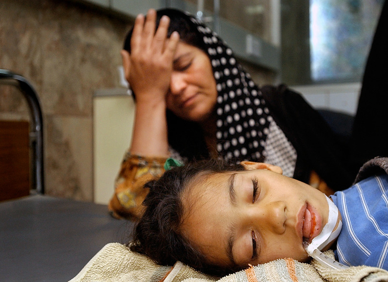 Sahara Ibrahim holds her head in grief while her daughter, Zena Jassim, 9, lays unconscious at Saddam Children's Park Nurse Villa Hospital in Baghdad, Iraq. Zena has been diagnosed with meningitis. Doctors said that the war environment caused a breakdown in public health services. The combination of poor sanitation and untreated water have led to an increase in infectious disease. (Chris Schneider/EW Scripps) 