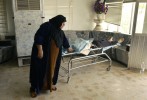 Najea Hussein Hammodi replaces the cover on a body at Al Nafas Hospital in Baghdad. The man was shot and killed by thieves. Looting and violence have increased since civil order broke down in Iraq after the U.S. invasion. (Chris Schneider/EW Scripps)