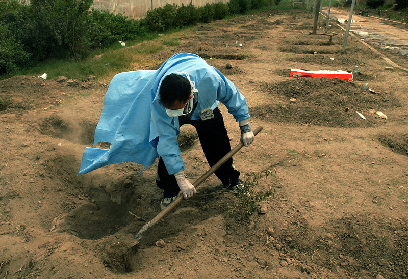 A volunteer digs up a body buried on the grounds at Saddam Children's park Nurse Villa Hospital in Bagdad. Islamic law states that a corpse must be buried within three days. During the war, so many unidentified bodies piled up at the hospital that they had to bury them outside the hospital.  The volunteers dig up the dead so that the family can identify them and then take them away for a proper burial. (Chris Schneider/EW Scripps)