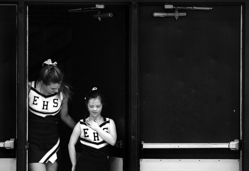 Fellow cheerleader Shanna Ancona helps Megan through the door at before a game at Evergreen High School in Evergreen, Colorado. Megan is on the cheerleading squad despite the fact she has Down syndrome.