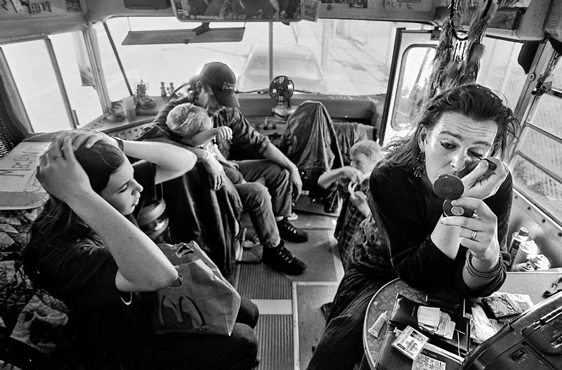 Inside the cramped quarters of the bus, Ramona puts on make-up before going to the Cannabis Club while the children prepare for dinner. Ramona uses marijuana and Greg drinks heavily.