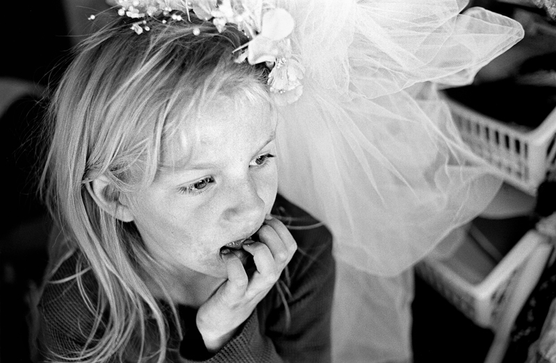 Zoe tries on a wedding veil while playing in the bus. The children are not in school and spend their time playing in the vacant lots around the bus.