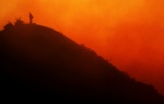 A lone firefighter stands on a mountain top at dusk near New Castle, Colo., on Tuesday, June 19, 2007. More people were evacuated Tuesday after the fire flared up in the afternoon. (Photo by Chris Schneider)